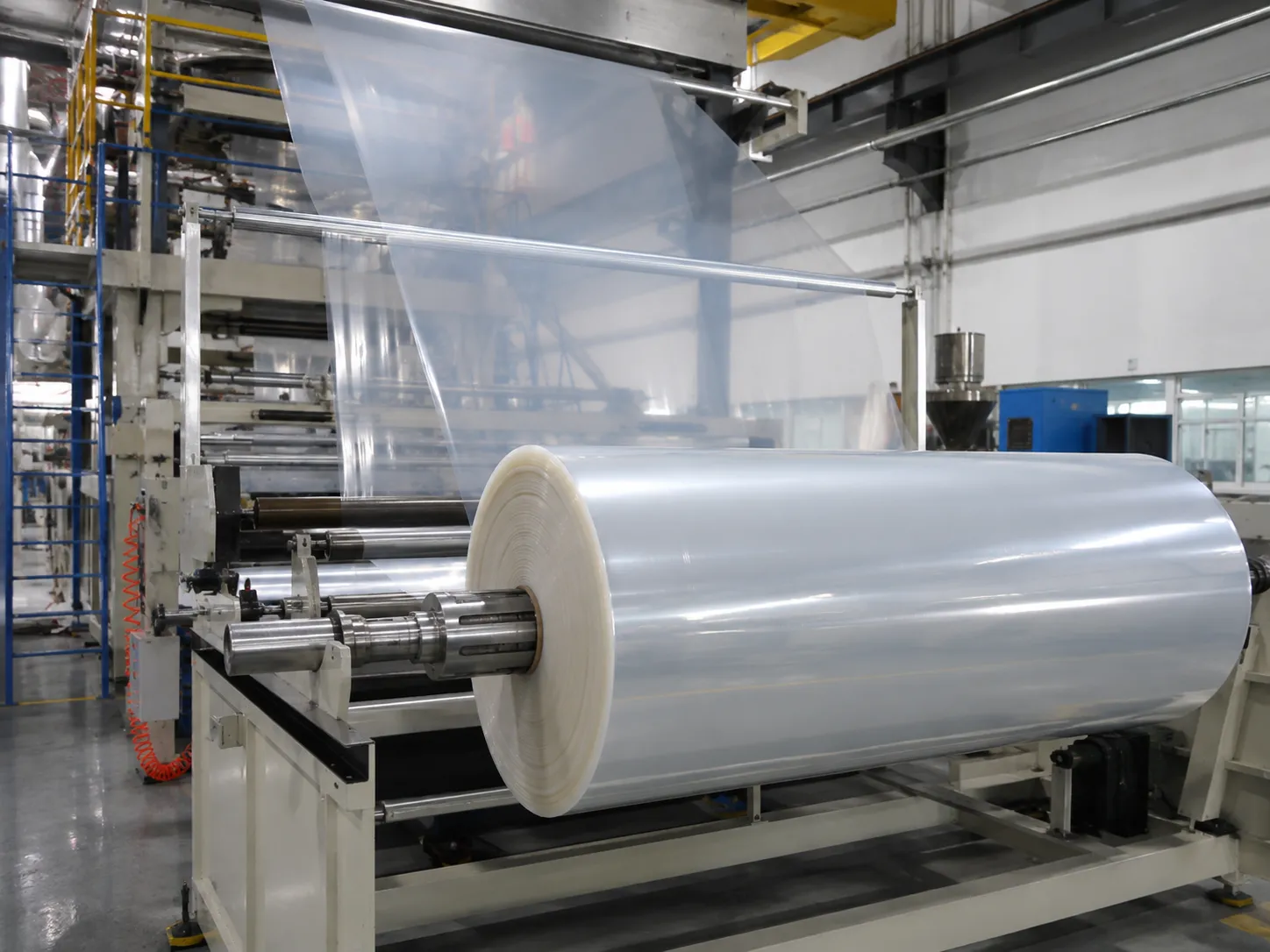 Plastic sheet and film extrusion line with PE film passing through metal rollers