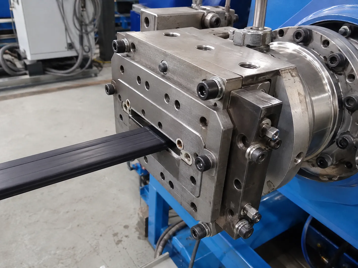 Custom rubber extruder die head extruding black profile strip with quick-change design at UET
