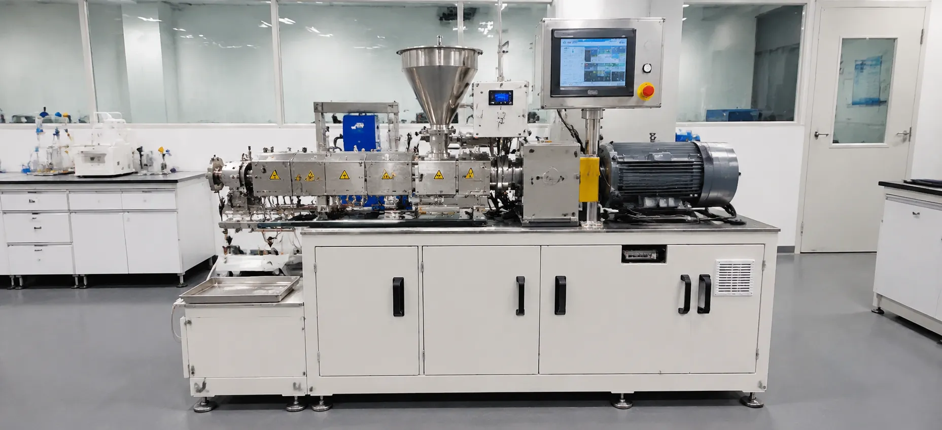 Compact lab scale triple screw extruder in clean laboratory environment with stainless steel conical hopper silver barrel yellow warning labels gray motor vertical touchscreen control panel with emergency stop button on white mobile cabinet for R&D pilot and university material research with direct scale-up to production models at UET Machine factory China CE ISO 9001